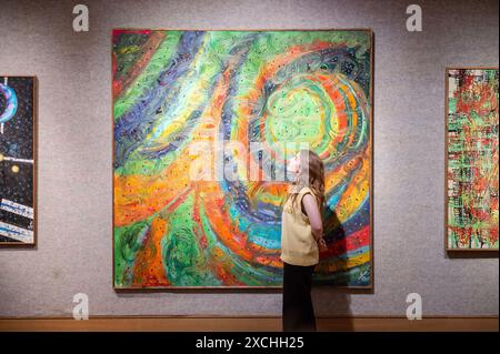 Londres, Angleterre, Royaume-Uni. 17 juin 2024. Un membre du personnel de Bonhams se tient à côté de Bertina Lopes (mozambicaine, 1924-2012) Gli attimi sono gli anelli del tempo (les moments sont les anneaux du temps), estimé à GBP 15 000 - GBP 20 000, pendant la séance photo. Le Studio de Bertina Lopes, une vente en ligne du 4-20 juin à Bonhams, présente une sélection de 74 peintures à l'huile, dessins et sculptures de l'atelier de l'artiste à Rome. (Crédit image : © Thomas Krych/ZUMA Press Wire) USAGE ÉDITORIAL SEULEMENT! Non destiné à UN USAGE commercial ! Banque D'Images