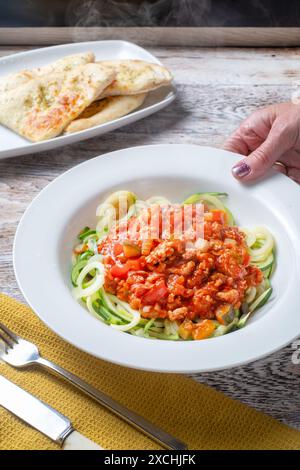 Un bol de ragu bolognaise servi sur un lit de courgettes spiralisées, courgetti ou courgettes, nouilles de courgettes. Une alternative à faible teneur en glucides céto aux pâtes Banque D'Images