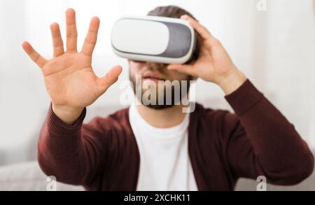 Homme avec une barbe portant un casque de réalité virtuelle, toucher l'air Banque D'Images