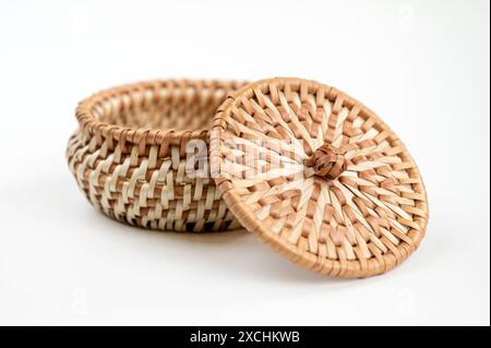 Panier en osier avec couvercle sur fond blanc. Le panier est fait de matériaux naturels. Banque D'Images