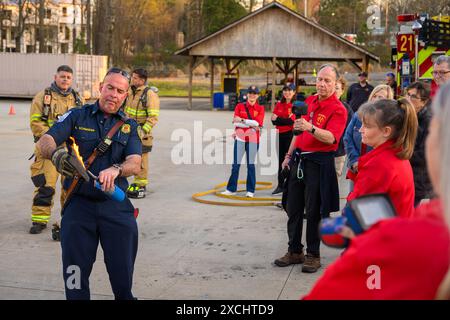 Citizens Fire Academy of Roswell Fire Department écoute l'instructeur capitaine Keith 'Doc' Schneider expliquer les avantages de l'utilisation d'un feu de maison de poupée p Banque D'Images