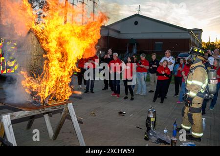 Citizens Fire Academy of Roswell Fire Department écoute l'instructeur capitaine Keith 'Doc' Schneider expliquer les avantages de l'utilisation d'un feu de maison de poupée p Banque D'Images