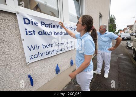 Stuttgart, Allemagne. 17 juin 2024. La dentiste Jessica Dreidoppel affiche une affiche de protestation sur la vitrine d’un cabinet dentaire. À côté d'elle se trouve le dentiste Alexander Raff. Les dentistes du Bade-Württemberg veulent quitter leur emploi le 18 juin 2024 pour protester contre la politique de santé et les soins aux patients dans leur secteur. Crédit : Marijan Murat/dpa/Alamy Live News Banque D'Images