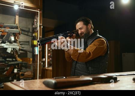 Pistolet de nettoyage de propriétaire de magasin d'armes avec brosse préparant des marchandises pour la vente Banque D'Images