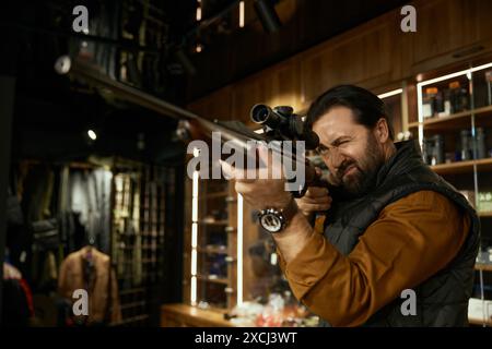 Homme chasseur client de viser pistolet tout en choisissant des munitions dans le magasin d'armes Banque D'Images