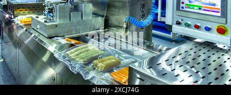 Les machines à haute performance emballent des produits alimentaires frais transformés, du porc, des saucisses.lignes de production alimentaire sur des bandes transporteuses, industrie de la production alimentaire Banque D'Images