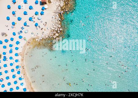 Vue aérienne d'une plage bondée de Konnos avec des touristes appréciant les vacances d'été, la baignade et les bains de soleil sur une journée ensoleillée. District de Famagouste, Chypre Banque D'Images