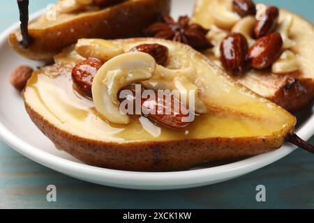 Délicieuses poires cuites au four avec des noix et du miel sur une table en bois bleu clair, gros plan Banque D'Images