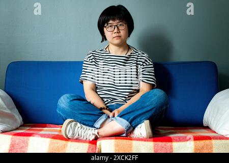 Portrait femme sur canapé gros plan portrait d'une jeune femme chinoise, étudiant dans une université néerlandaise. Tilburg, pays-Bas. MRYES Tilburg Studio Tuinstraat Noord-Brabant Nederland Copyright : xGuidoxKoppesxPhotox Banque D'Images