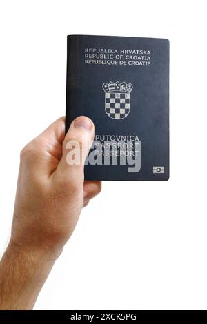 Gros plan sur la main d'un homme tenant un passeport de Croatie sur fond blanc. Banque D'Images