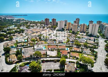 Vue aérienne Dehesa de Campoamor, village à Orihuela Costa. Quartier résidentiel avec des maisons, entouré de verdure, immeubles d'appartements près de la côte, Banque D'Images