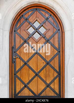 Belle porte d'entrée d'un bâtiment historique. La porte a une forme arquée. La porte est en bois laqué doré. Banque D'Images