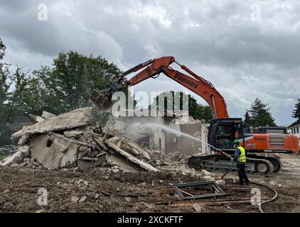 Duesseldorf, Allemagne. 17 juin 2024. Une excavatrice est occupée à démolir un bâtiment détruit, un ouvrier de la construction se tient à côté de lui pulvérisant de l'eau contre la poussière. Crédit : Wolf von Dewitz/dpa/Alamy Live News Banque D'Images