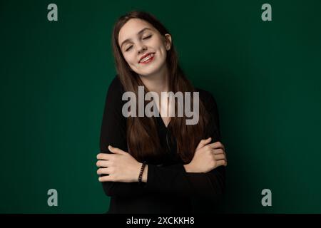 Femme avec les bras croisés devant le fond vert Banque D'Images