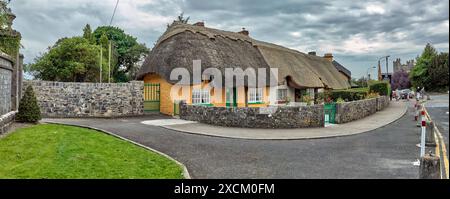 Route en face des maisons de village aux toits de chaume, Adare, comté de Limerick, Irlande Banque D'Images