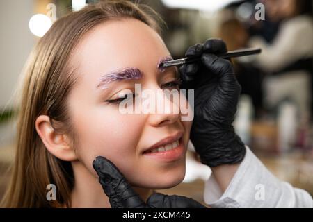 Portrait de jeune dame au cours de la procédure de lamination des sourcils. Banque D'Images