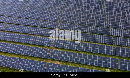 Vue aérienne fermée des rangées de panneaux solaires sur le champ vert. Banque D'Images