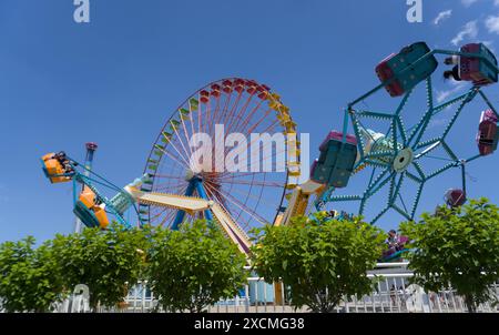 Sandusky, Ohio, USA / 13 juin 2024 - roue colorée derrière deux tours rotatifs à Cedar point Sandusky, Ohio Banque D'Images