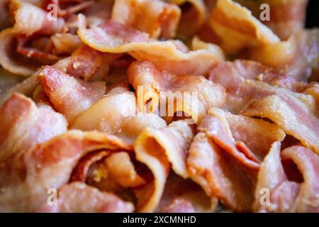 Bacon grésille dans une poêle sur un gril extérieur Banque D'Images