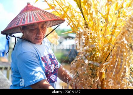 Un homme prépare des accessoires traditionnels pour le rituel Melanau serahang pendant le festival de Kaul Banque D'Images