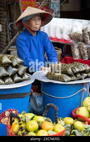 Femme âgée Hmong vendant de la nourriture au marché bac Ha, province de Lao Cai, Vietnam Banque D'Images