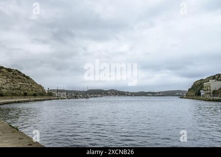 Journée couverte à PorA vue sereine sur le port de Mahon à Minorque, avec des eaux calmes, des bateaux amarrés, et les collines environnantes sous un ciel couvert.t de ma Banque D'Images