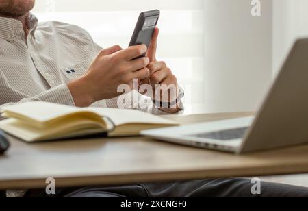 Gros plan, homme d'affaires utilisant un téléphone intelligent mobile. homme utilisant un smartphone pendant le travail au bureau, concept de réseau social Banque D'Images