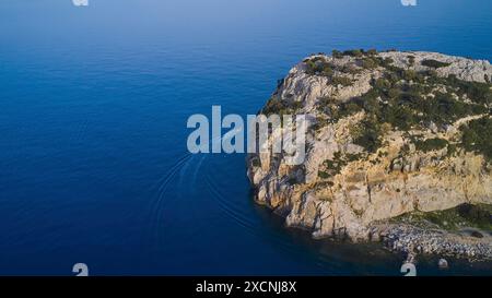 Tir de drone, bateau naviguant le long d'une falaise rocheuse au-dessus de la mer bleue claire, Anthony Quinn Bay, Vagies Bay, Rhodes, Dodécanèse, îles grecques, Grèce Banque D'Images