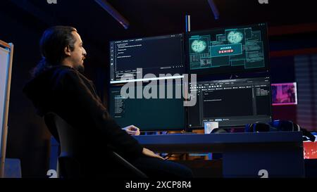 Hacker dans un appartement caché essayant de voler des données précieuses en ciblant des sites Web gouvernementaux, mais obtenant l'accès refusé message d'erreur, ayant les cyberattaques rejetées, caméra B. Banque D'Images