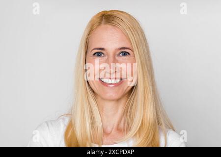 Portrait de femme joyeuse avec des cheveux blonds en chemise blanche Banque D'Images