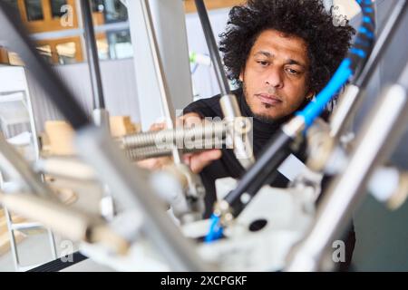 Ingénieur spécialisé travaillant sur la programmation d'un bras de préhension robotique, mettant en évidence le développement robotique, l'automatisation industrielle et la technologie de pointe. Banque D'Images