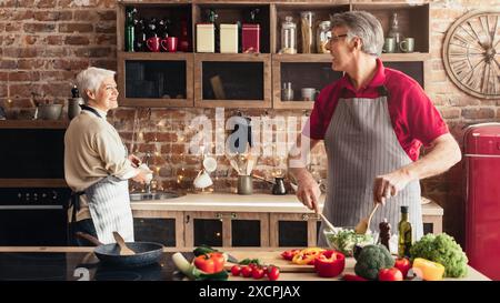 Joyeux mari et femme âgés préparant le dîner ensemble Banque D'Images