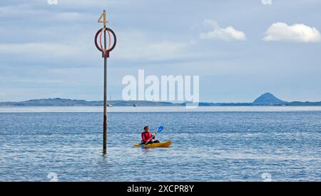 Firth of Forth, Portbello, Édimbourg, Écosse, Royaume-Uni. Un mâle qui pagaie dans un kayak jaune dans le soleil lumineux juste à côté de la plage de Portobello avec une température de 16 degrés centigrades. Credit : Arch White/Alamy Live news. Banque D'Images