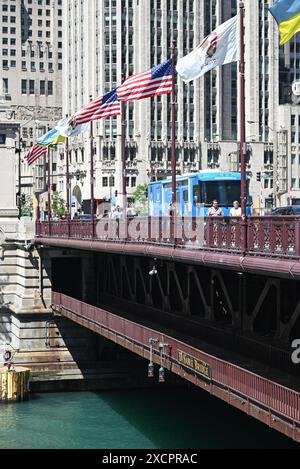 Des drapeaux soufflent dans le vent le long du pont DuSable où Michgan Avenue traverse la rivière Chicago. Banque D'Images