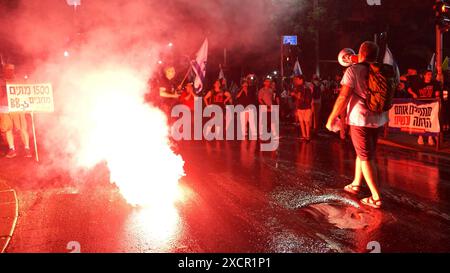 JÉRUSALEM - 17 JUIN : des manifestants antigouvernementaux scandent des slogans alors qu'ils laissent échapper la fumée rouge lors d'une manifestation près de la résidence privée du premier ministre, contre le gouvernement de Netanyahou et appelant à de nouvelles élections le 17 juin 2024 à Jérusalem. Les frustrations des Israéliens envers le gouvernement dirigé par Benjamin Netanyahou ont persisté alors que plus de 100 otages restent captifs à Gaza, après près de huit mois de guerre entre Israël et le Hamas, le groupe militant palestinien qui a attaqué Israël le 7 octobre. Banque D'Images