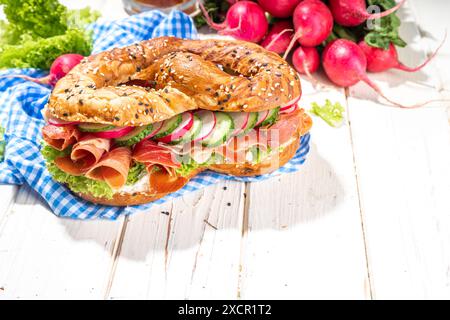 Sandwich au bagel Oktoberfest bretzel. Petit déjeuner Oktoberfest, recette de hamburger pour les fêtes de fête de la bière. Grand bretzel avec jambon, fromage, légumes frais, W Banque D'Images