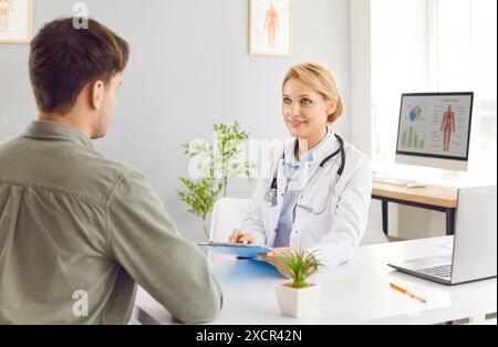 Jeune femme médecin portant un uniforme médical blanc parlant pour discuter des résultats ou des symptômes Banque D'Images