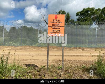 Karsava, Lettonie. 18 juin 2024. "Stop - State Border" est écrit en trois langues sur un panneau à la frontière lettone avec la Russie. Crédit : Alexander Welscher/dpa/Alamy Live News Banque D'Images