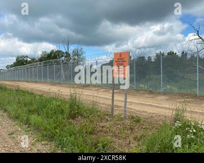 Karsava, Lettonie. 18 juin 2024. "Stop - State Border" est écrit en trois langues sur un panneau à la frontière lettone avec la Russie. Crédit : Alexander Welscher/dpa/Alamy Live News Banque D'Images