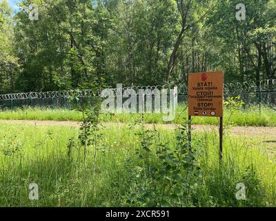 Karsava, Lettonie. 18 juin 2024. "Stop - State Border" est écrit en trois langues sur un panneau à la frontière lettone avec la Russie. Crédit : Alexander Welscher/dpa/Alamy Live News Banque D'Images