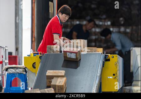 Hangzhou, province chinoise du Zhejiang. 17 juin 2024. Un ouvrier se prépare pour l'expédition dans une entreprise alimentaire dans le canton de Xiaoshun de la ville de Jinhua, dans la province du Zhejiang de l'est de la Chine, le 17 juin 2024. Au cours de la campagne d'achat de mi-année du pays, connue sous le nom de festival d'achat '618', les entreprises de commerce électronique et de logistique, ainsi que les entreprises en ligne et hors ligne, se sont bien préparées à faire face à la demande croissante. Crédit : HU Xiaofei/Xinhua/Alamy Live News Banque D'Images