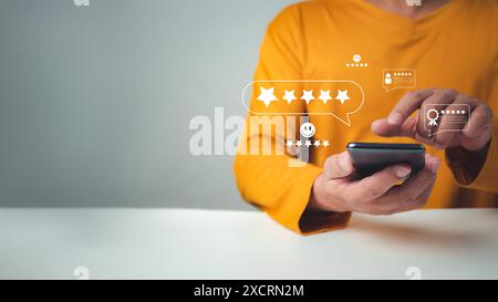 Homme d'affaires tenant smartphone avec une case à cocher sur excellent Smiley face et Rating pour une enquête de satisfaction, évaluation de la qualité du service du produit par Banque D'Images