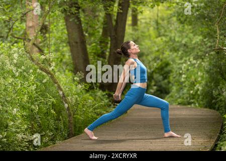 Femme sportive faisant du yoga dans le parc, exercice d'étirement Banque D'Images