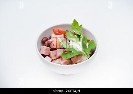 Salade de légumes avec viande et sauce dans un saladier blanc. Une petite collation. Banque D'Images