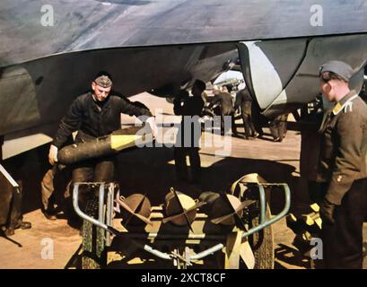 Une photographie capture un technicien en bombe de la Luftwaffe inspectant des munitions avant un vol pendant la seconde Guerre mondiale. En tant que membres de l'armée de l'air allemande, ces techniciens ont joué un rôle essentiel dans le succès des raids de bombardement en préparant et en entretenant les bombes. Banque D'Images