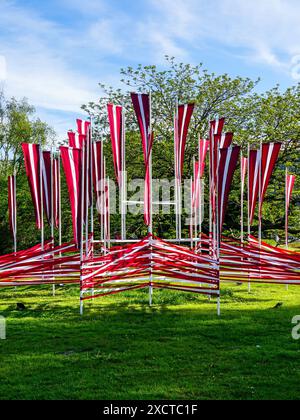 De nombreux drapeaux nationaux de Lettonie flottent dans le vent comme décoration de la place de la ville pendant les fêtes nationales Banque D'Images