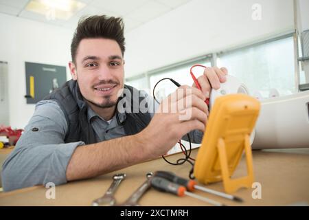 gros plan d'un électricien tenant le voltmètre Banque D'Images