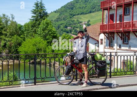 Pèlerin à vélo le Camino de Santiago sur le pont au-dessus de la rivière Nive dans la ville française de St Jean pied de Port au début du chemin de St James Banque D'Images