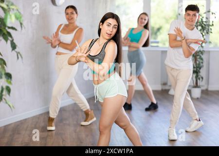 Adolescente hispanique pratiquant la danse énergétique en classe de chorégraphie Banque D'Images