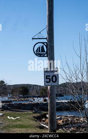 Voilier et panneaux de limitation de vitesse à Mahone Bay, Nouvelle-Écosse, Canada Banque D'Images